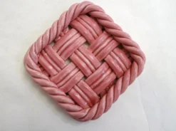 Paire de dessous de bouteilles tressés, en faïence rose Vallauris