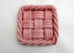 Paire de dessous de bouteilles tressés, en faïence rose Vallauris