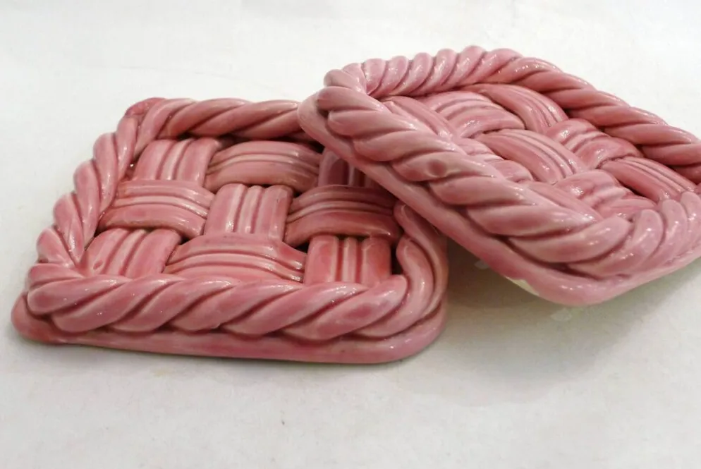 Paire de dessous de bouteilles tressés, en faïence rose Vallauris