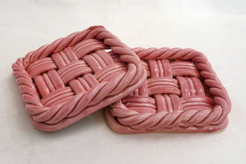Paire de dessous de bouteilles tressés, en faïence rose Vallauris
