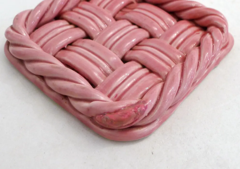 Paire de dessous de bouteilles tressés, en faïence rose Vallauris