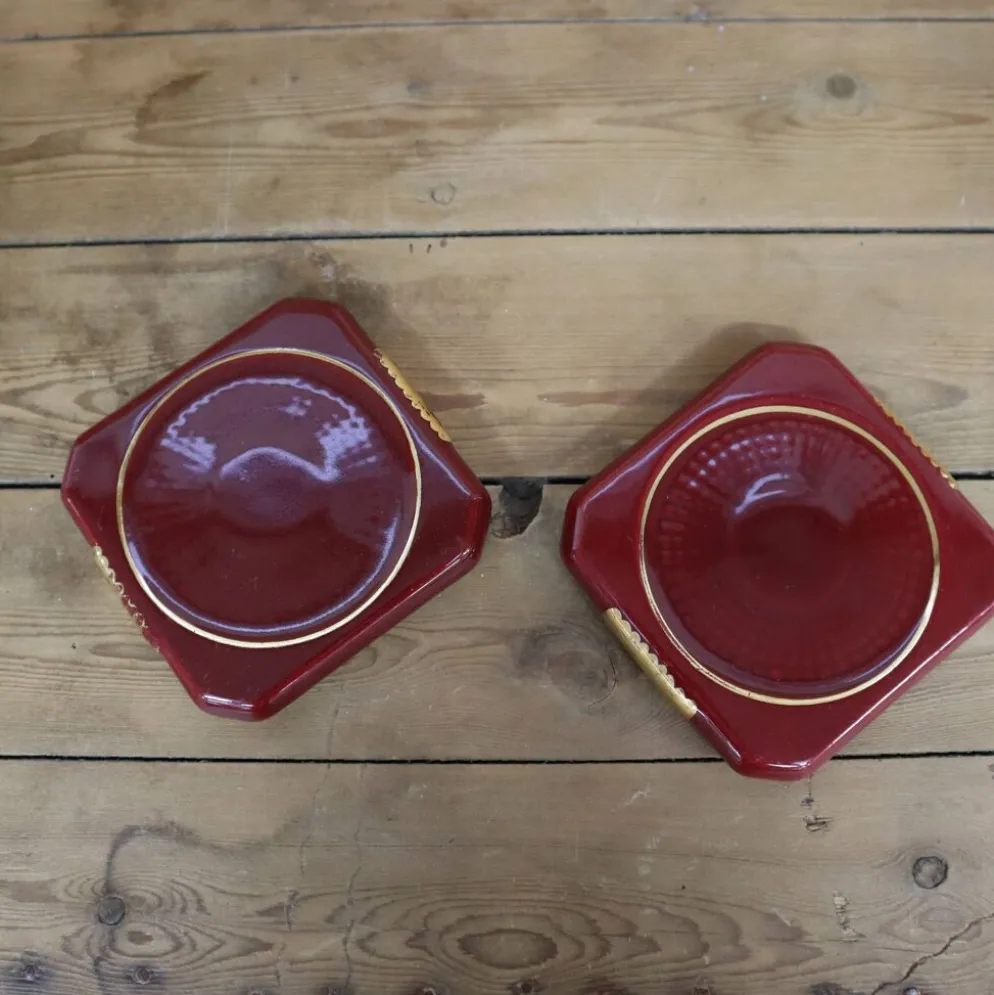 Paire de dessous de plat ou bouteilles en céramique bordeaux avec liseré doré