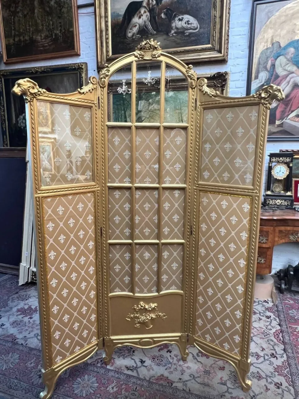 Paravent en bois doré décoré dans le style Louis XVI, orné de têtes de bélier.