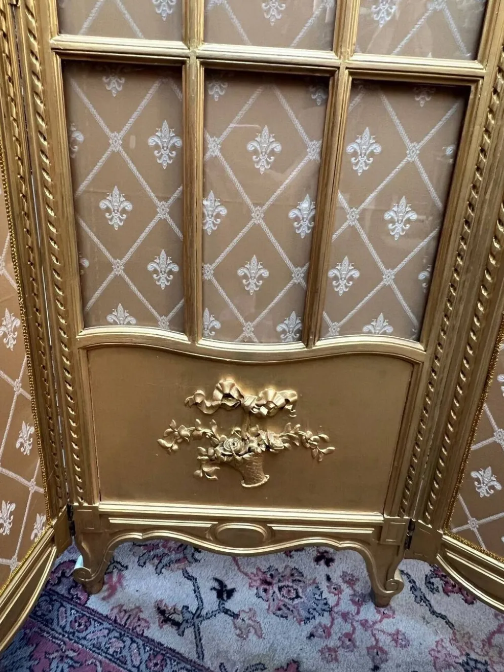 Paravent en bois doré décoré dans le style Louis XVI, orné de têtes de bélier.