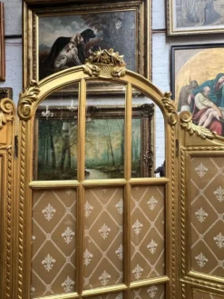 Paravent en bois doré décoré dans le style Louis XVI, orné de têtes de bélier.