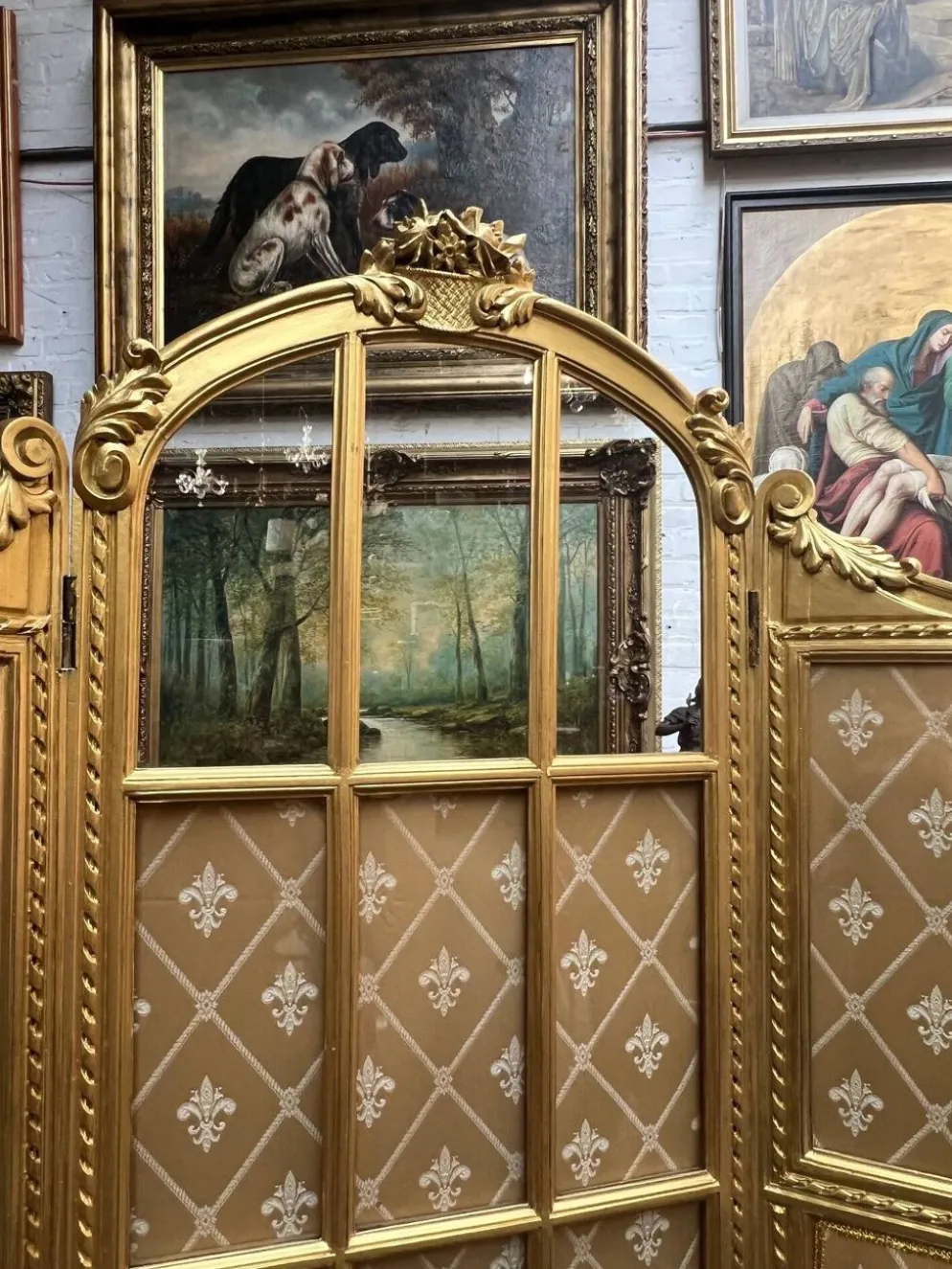 Paravent en bois doré décoré dans le style Louis XVI, orné de têtes de bélier.