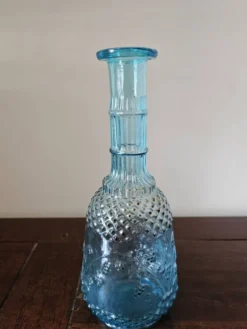Petite carafe vintage en verre bleu turquoise moulé à décor floral