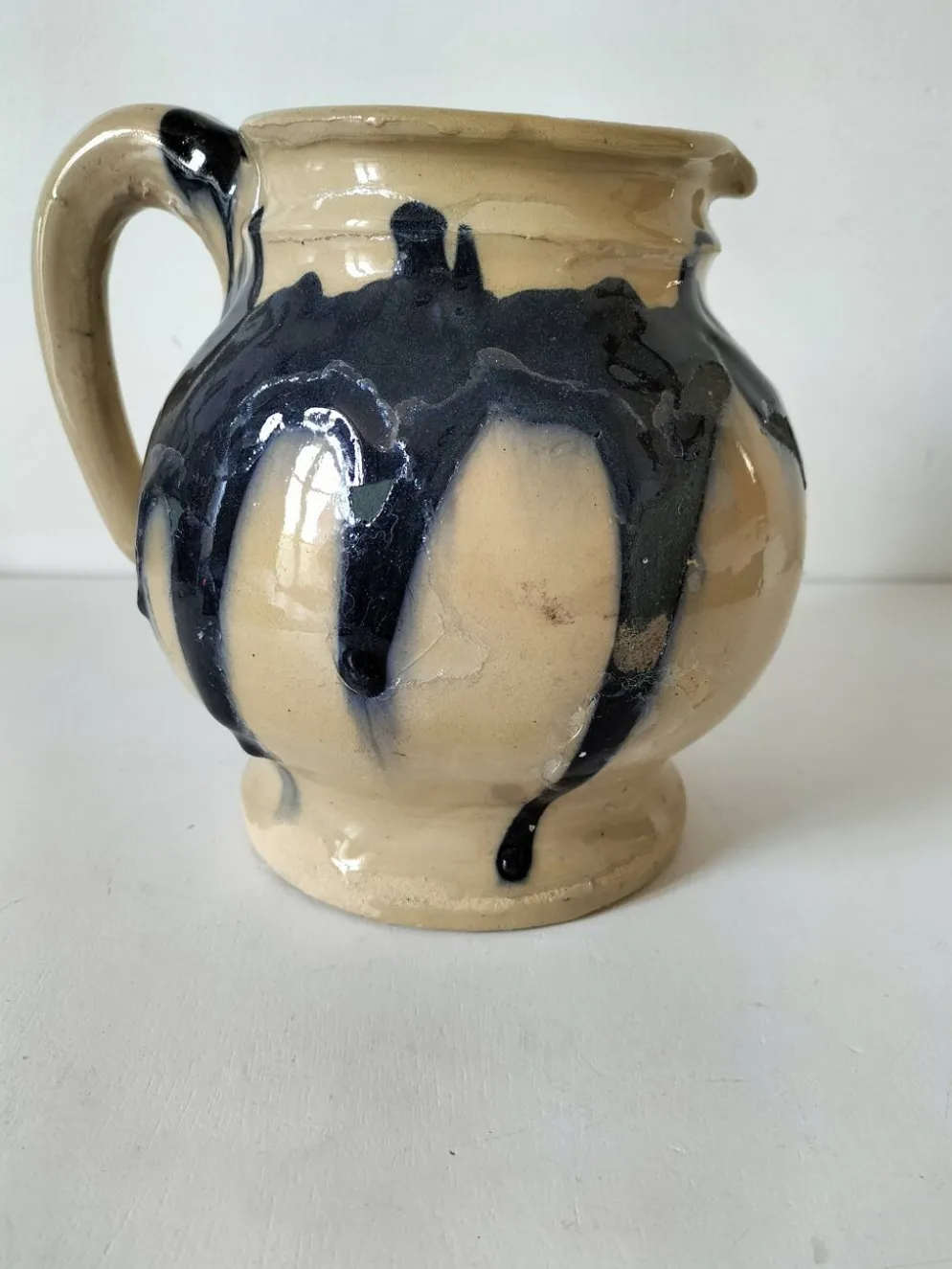 pichet artisanal en céramique émaillée à coulures bleu marine.