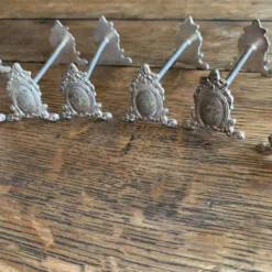 Série de 12 porte-couteaux en métal argenté monogrammé