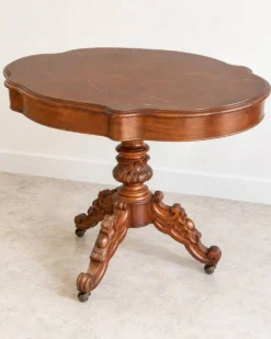 Table ancienne en bois sculpté – plateau chantourné et roulettes