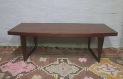 Table basse en palissandre danois avec un dessus courbé sur des pieds en traîneau par Leif Hansen, années 1960.