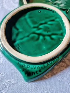 Un dessous de plat et deux de bouteilles en majolique verte Vallauris