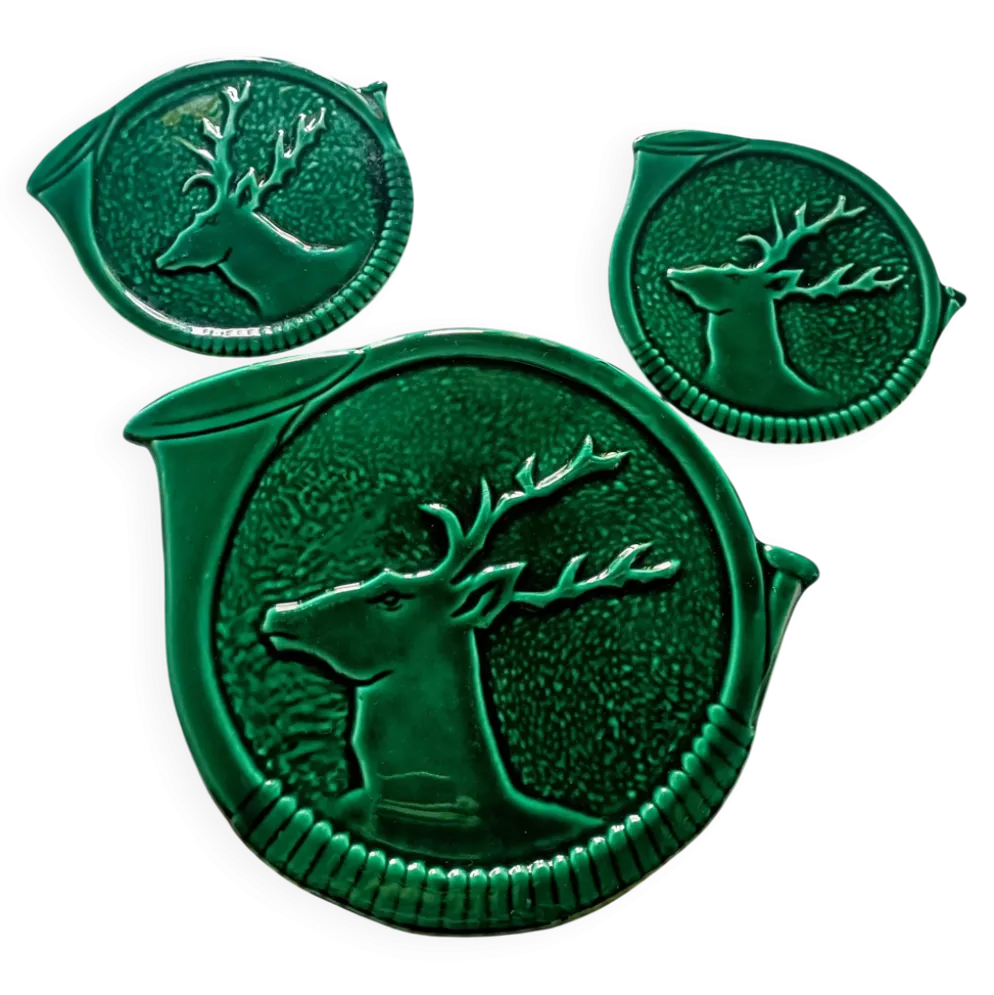 Un dessous de plat et deux de bouteilles en majolique verte Vallauris