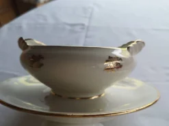 Vends saucière Élégant décor de petites roses dorées,
