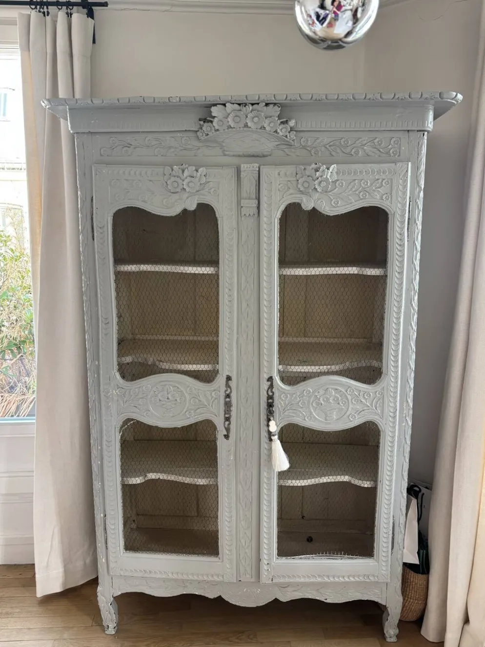Vitrine ancienne française en bois sculpté avec portes en treillis métallique.